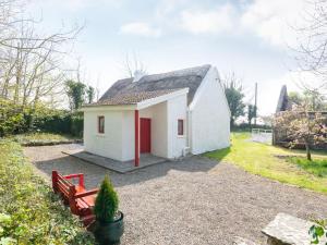 a small white house with a red door at Holiday Home The Neale by Interhome in Cross