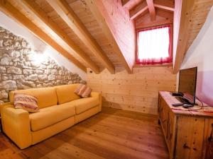 a living room with a couch and a television at Apartment Albergo Diffuso - Cjasa Ustin-3 by Interhome in Barcis