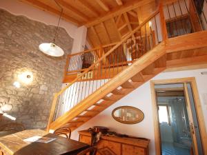 escalera de madera en una habitación con pared de piedra en Apartment Albergo Diffuso - Cjasa Ustin-3 by Interhome, en Barcis