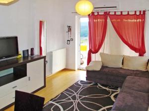 a living room with a couch and a television at Apartment Chantal-4 by Interhome in Rabac