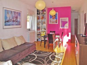 a living room with a couch and a pink wall at Apartment Chantal-4 by Interhome in Rabac