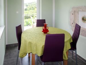 a dining room with a yellow table and purple chairs at Holiday Home Mirela by Interhome in Martina