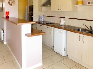 a kitchen with white cabinets and a sink at Holiday Home La Chapelle - CON100 by Interhome in Contis-les-Bains