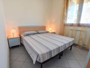 una camera con un letto con due comodini e due lampade di Apartment Solmare-7 by Interhome a Rosapineta