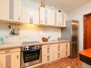 カルプにあるHoliday Home Casa Jara by Interhomeのキッチン(白いキャビネット、ステンレス製の冷蔵庫付)