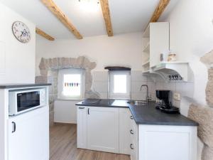 a kitchen with white cabinets and a counter top at Holiday Home San Martino I by Interhome in Mošćenička Draga