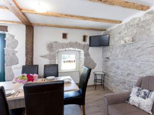 a dining room with a table and a stone wall at Holiday Home San Martino I by Interhome in Mošćenička Draga +20 photos