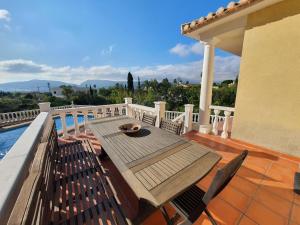 a deck with a wooden table and chairs on a house at Holiday Home Osa Menor by Interhome in Montgo