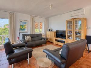 a living room with black leather furniture and a television at Holiday Home Osa Menor by Interhome in Montgo