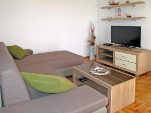 a living room with a couch and a tv at Apartment Luka - NOV103 by Interhome in Novi Vinodolski