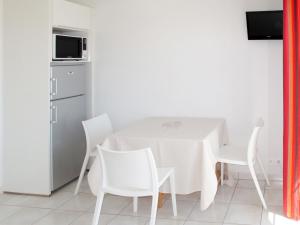 a white dining room with a white table and chairs at Apartment Résidence Belle Dune - BPL332 by Interhome in Biscarrosse-Plage