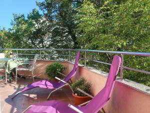 two purple chairs and a table on a balcony at Apartment Vera - MLK326 by Interhome in Malinska