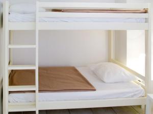 ビスカロッス・プラージュにあるApartment Résidence Belle Dune - BPL332 by Interhomeの白い二段ベッドが備わる客室です。