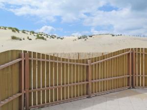 una valla de madera con dunas de arena en el fondo en Holiday Home Résidence Plage Océane-2 by Interhome, en Biscarrosse-Plage