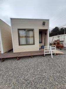 a tiny house with a porch and a swing at Cabañas MI REFUGIO in Isla Negra