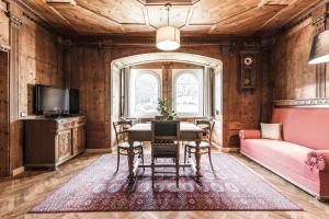 una sala da pranzo con tavolo e divano di Villa Martiner Apartments Moritz a Ortisei