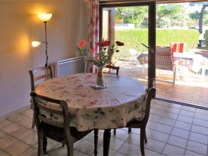 ビスカロッス・プラージュにあるHoliday Home Les Palourdes - BPL460 by Interhomeの花瓶付きのテーブルと椅子