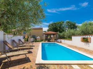 a swimming pool with chairs and a house at Holiday Home Ksenija-2 by Interhome in Čepljani