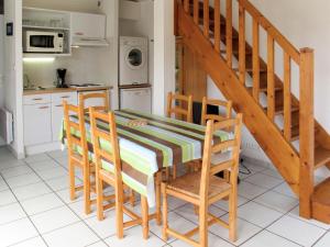 a kitchen with a table and chairs and a staircase at Holiday Home Résidence Dune Blanche - Soleil - BPL320 by Interhome in Biscarrosse-Plage