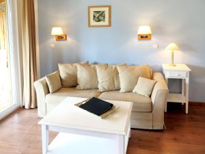een woonkamer met een bank en een tafel bij Apartment Les Cottages du Lac T3 by Interhome in Parentis-en-Born +20 foto's
