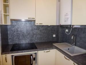 a kitchen with white cabinets and a sink at Apartment Le Nirvana-1 by Interhome in Le Grau-du-Roi