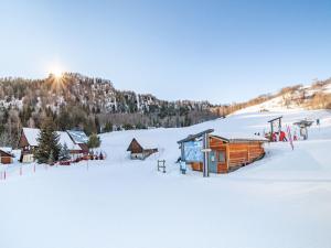 a cabin in the snow with the sun in the background at Apartment Le Bochate-5 by Interhome in Saint-Pancrace