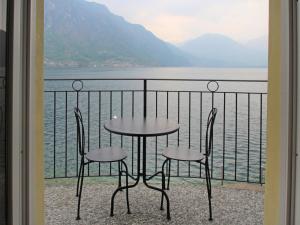 ClainoにあるApartment La Pocetta-1 by Interhomeのテーブルと椅子2脚、水辺を見渡すバルコニー