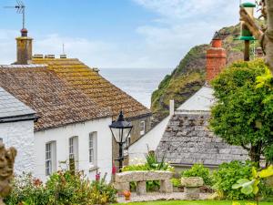 een rij huizen met de oceaan op de achtergrond bij Holiday Home The Homestead by Interhome in Gorran Haven