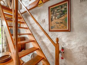 una escalera de madera en una casa con una pintura en la pared en Holiday Home The Homestead by Interhome en Gorran Haven