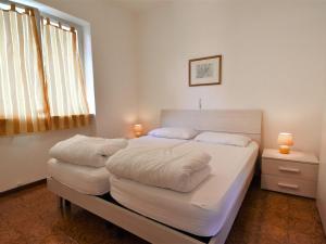 a bedroom with a large white bed with two pillows at Apartment Villa Laura-4 by Interhome in Crone