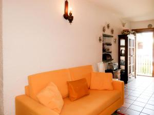 un divano arancione in soggiorno di Apartment Ludovica by Interhome a Stazzona