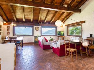 ein Wohnzimmer mit Sofas, Tischen und Fenstern in der Unterkunft Holiday Home Villa Madda by Interhome in Dongo