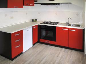a kitchen with red cabinets and a sink and a stove at Holiday Home Matea - MOD207 by Interhome in Martina