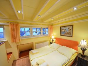 a bedroom with a bed with an orange headboard and windows at Holiday Home Dünenrose by Interhome in Groß Zicker