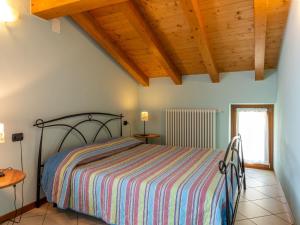 sypialnia z łóżkiem i drewnianym sufitem w obiekcie Holiday Home Elisa by Interhome w mieście Sorico