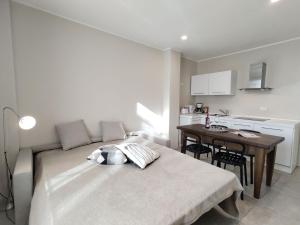 a bedroom with a bed and a table and a kitchen at Apartment Federico by Interhome in Olgiasca