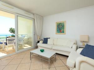 a living room with a white couch and a table at Apartment Le Grand Large by Interhome in Juan-les-Pins