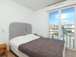 a bedroom with a bed and a large window at Apartment Le Grand Large by Interhome in Juan-les-Pins