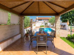 a patio with a table and chairs and a pool at Holiday Home Ksenija-1 by Interhome in Čepljani