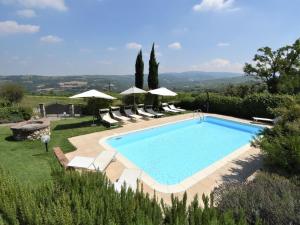 una piscina con tumbonas y sombrillas en Apartment La Corte Bricca - Bilo D by Interhome, en Castana