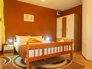 una camera da letto con un letto con una parete rossa di Apartment Donata by Interhome a Senj