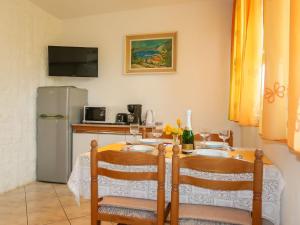una cucina con tavolo con 2 sedie e frigorifero di Apartment Donata by Interhome a Senj