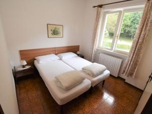 Bett in einem Zimmer mit einem großen Fenster in der Unterkunft Apartment Villa Laura by Interhome in Crone