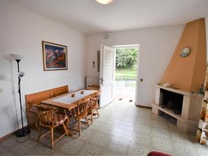 ein Esszimmer mit einem Tisch, Stühlen und einem Kamin in der Unterkunft Apartment Villa Laura by Interhome in Crone