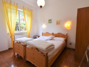 クロネにあるApartment Villa Laura by Interhomeのベッドルーム1室(黄色のカーテン付きの大型ベッド1台付)