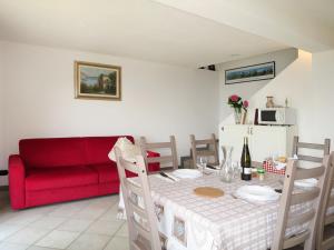 un soggiorno con tavolo e divano rosso di Holiday Home Pineta by Interhome a Porlezza
