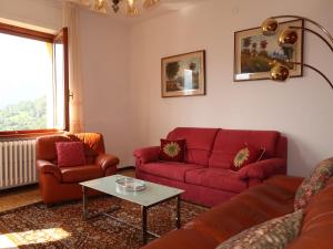 グラヴェドーナにあるApartment Gialla by Interhomeのリビングルーム(赤いソファ、テーブル付)