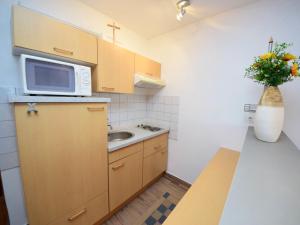 a small kitchen with a sink and a microwave at Apartment Šarić-1 by Interhome in Trogir