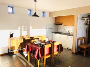 eine Küche mit einem Tisch und einem roten Tischtuch darauf in der Unterkunft Holiday Home Au bord du Lac-1 by Interhome in Bütgenbach