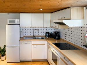 a kitchen with a white refrigerator and a sink at Holiday Home Vosshörn by Interhome in Westerschoo